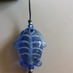close up of blue glass fish bead on bookmark